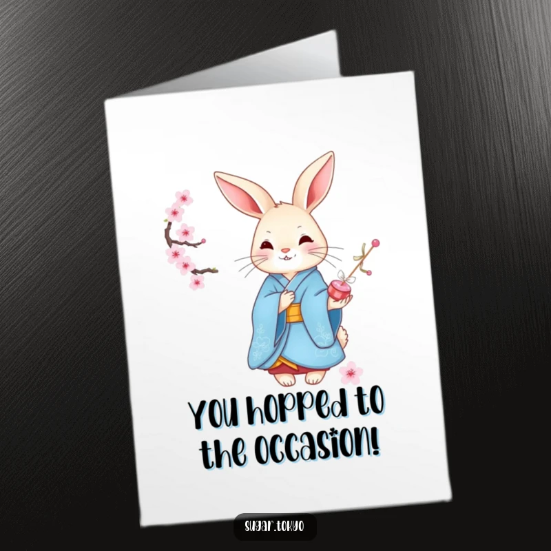 Funny Free Printable Congrats Card: Graceful rabbit in an elegant blue kimono offers cherry blossom candies to celebrate your success.